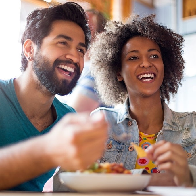 Young couple enjoying a meal and a drink in a restaurant